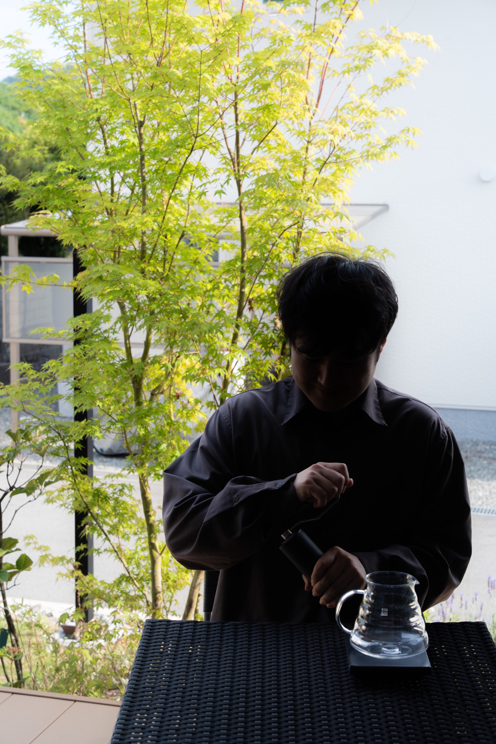 緑の木々を背景にコーヒーを淹れているJAKKYの写真